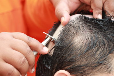 Midsection of barber shaving man head in salon
