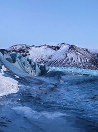 Scenic view of snowcapped mountains against clear blue sky