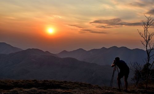 Man photographing at sunset