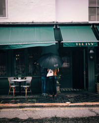 Rear view of man standing on wet street during monsoon