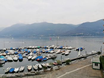 Sailboats moored in sea against sky