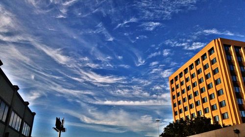 Low angle view of buildings against cloudy sky