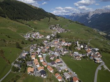 High angle view of houses on field by mountain