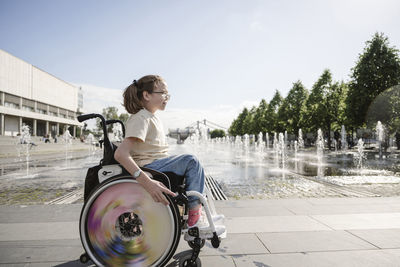 Girl sitting on wheelchair at park