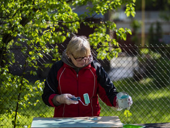 Midsection of woman using mobile phone outdoors