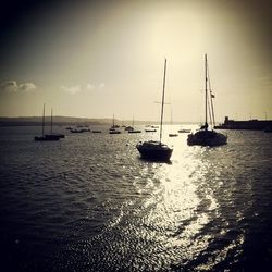 Boats in sea at sunset