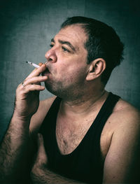 Man smoking against wall