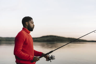 Side view of man fishing during sunset