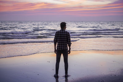 Rear view of woman standing on beach