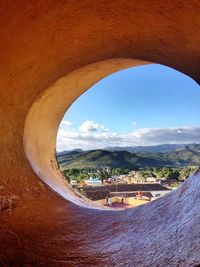 Scenic view of landscape against sky seen through arch