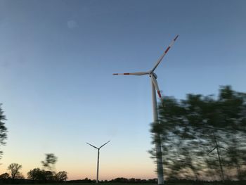 Low angle view of windmill on field against sky