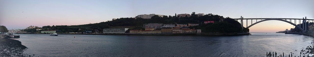 Bridge over river amidst buildings against clear sky