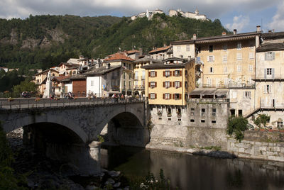 Bridge over river by mountain against sky