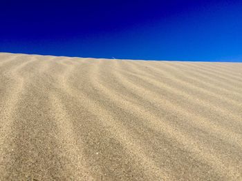 Scenic view of desert against clear blue sky