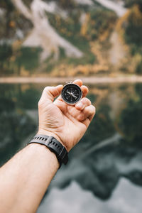 Cropped hand of man holding navigational compass