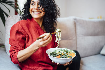 Brunette woman eating a healthy green salad.