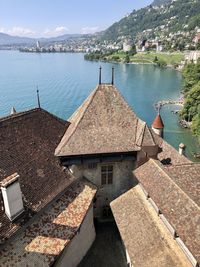 High angle view of houses by lake and buildings against sky