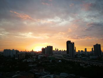 Modern buildings against sky during sunset