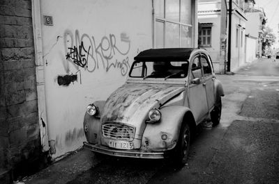 View of abandoned car on street against building