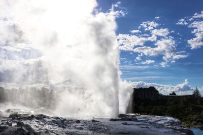 Scenic view of waterfall against sky