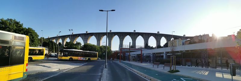 Cars on bridge against sky in city