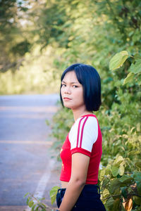 Girl looking away while standing on plant