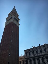 Low angle view of clock tower against blue sky