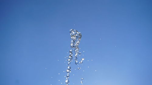 Close-up of water splashing against blue sky