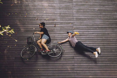 Women sitting on bicycle against brick wall