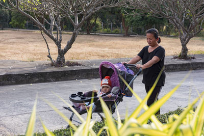 Happy little baby learning to walk with mother help at home.