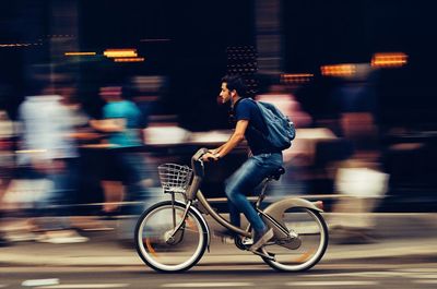 Side view of man riding bicycle on road