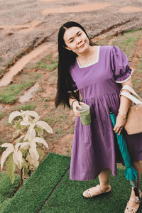 Young woman standing on purple flower