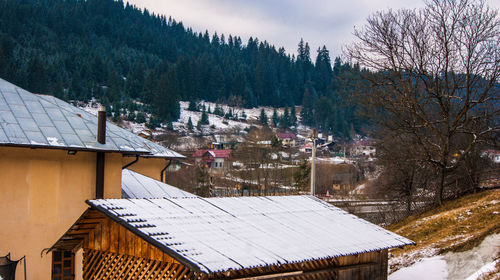 High angle view of houses and trees on snow covered landscape