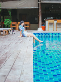 Rear view of woman standing in swimming pool