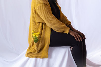 Midsection of woman standing against curtain