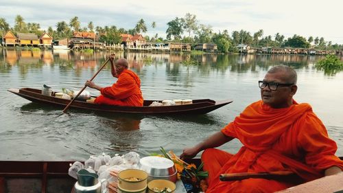 Men sitting on boat in river