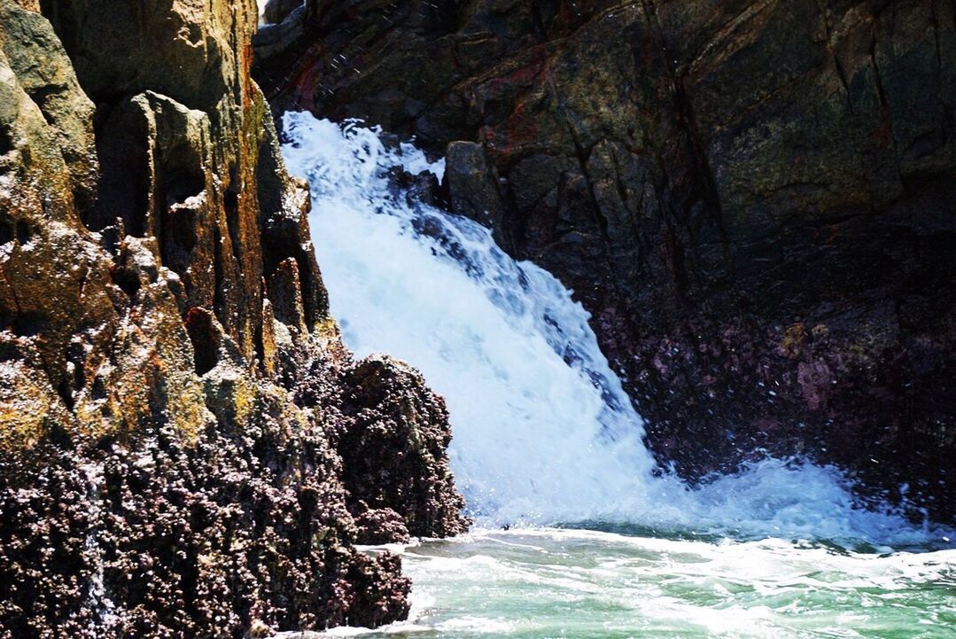 SCENIC VIEW OF WATERFALL ON ROCK FORMATION