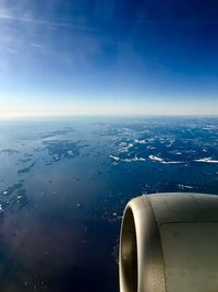 Airplane flying over sea against sky