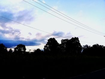 Low angle view of silhouette trees against sky