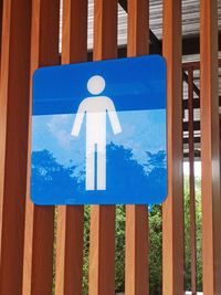 Close-up of sign board against blue sky