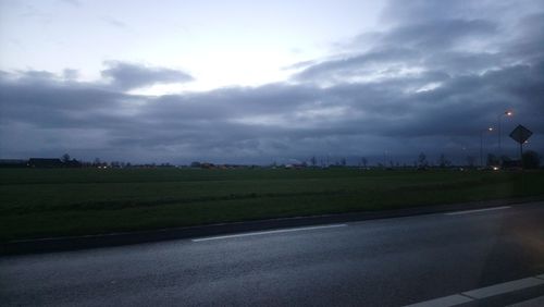 Road in city against storm clouds