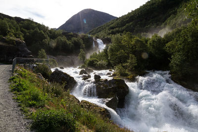 Scenic view of waterfall against sky