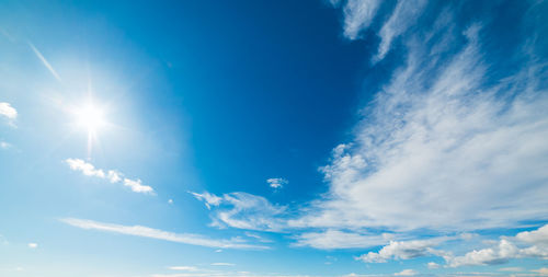 Low angle view of sunlight streaming through clouds