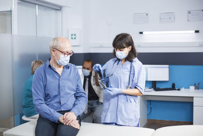 Rear view of doctor working in office