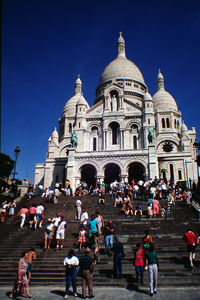 Low angle view of people at basilique du sacre coeur against clear blue sky