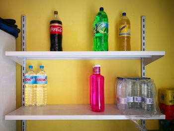 Row of bottles on shelf against wall