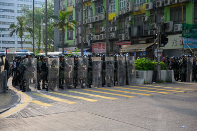 Group of people on city street against buildings