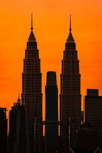 Silhouette of buildings against orange sky