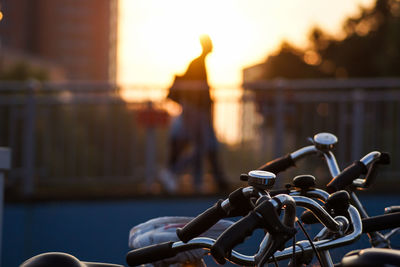 Close-up of bicycle in city during sunset