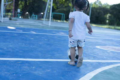 Rear view of girl playing tennis